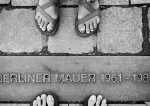 Frauenfüße am Schriftzug auf der Straße "Berliner Mauer 1961-1989"