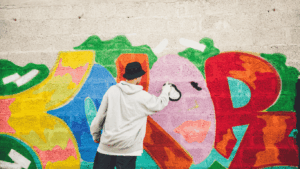 Jugendlicher sprayt eine Wand