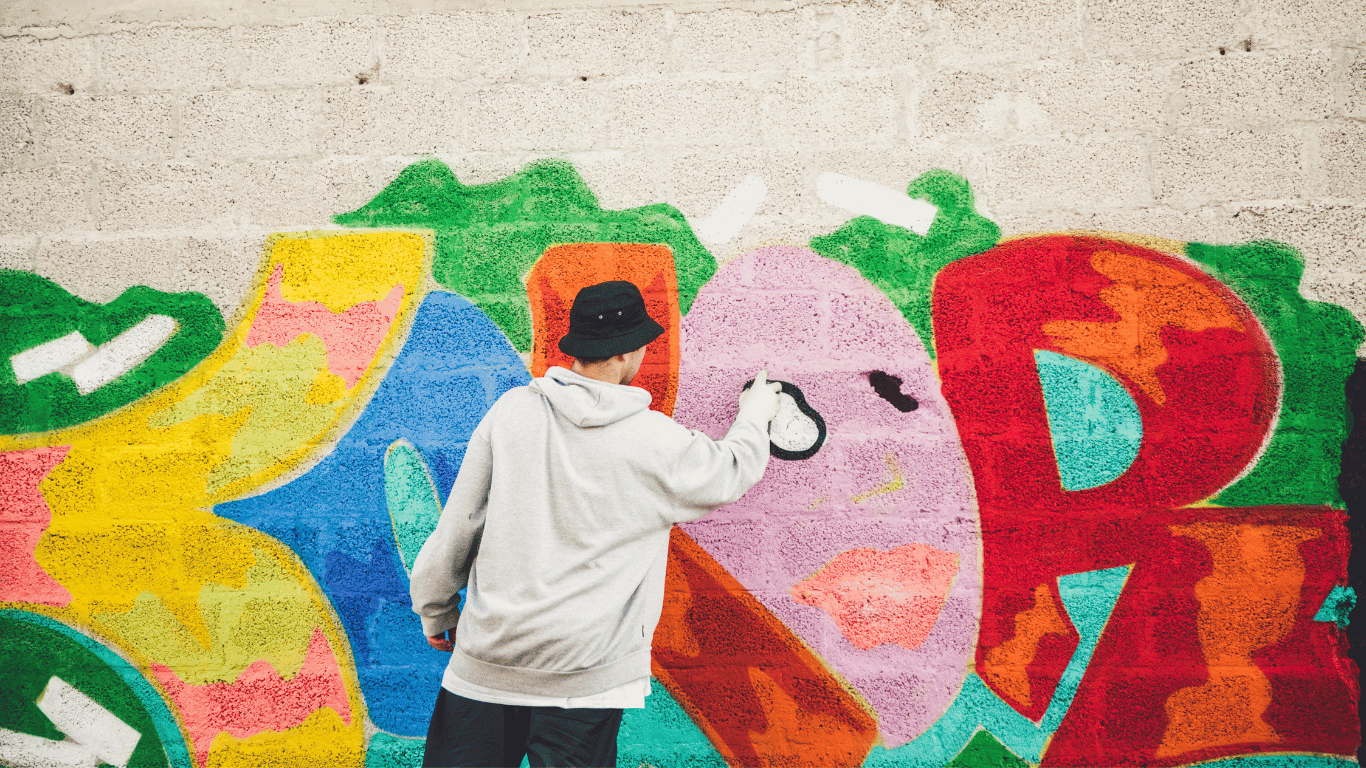 Jugendlicher sprayt eine Wand
