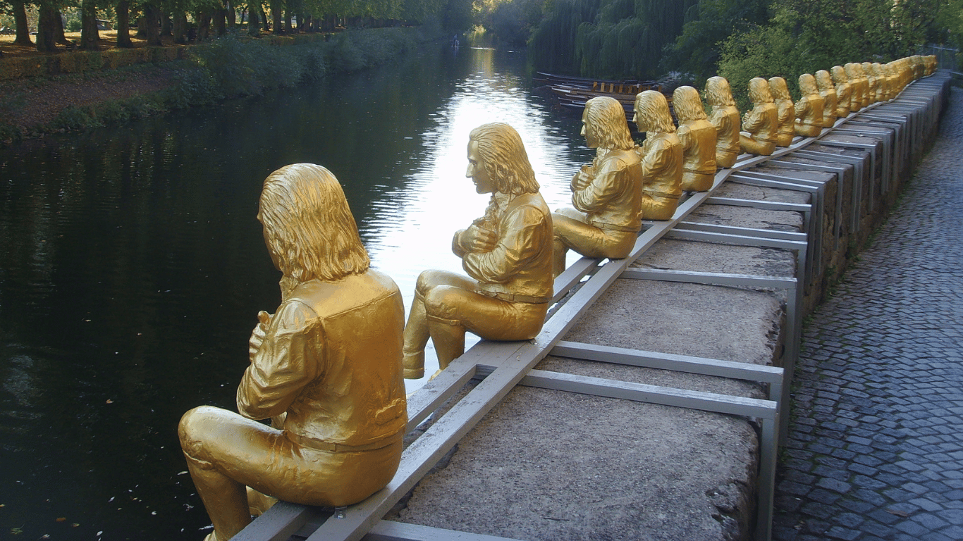 Temporäre Ausstellung in Tübingen an dem viele goldene Hölderlin-Statuetten am Fluss sitzen.