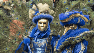 Zwei Personen mit venetianischer Maske und Kostüm mit Pfauenfedern.