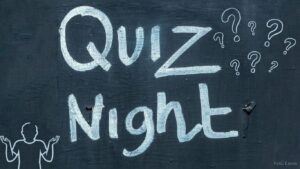 Tafel auf der "Quiz Night" steht, drumherum Fragezeichen