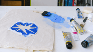 Sternschablone auf einer Leinentasche, daneben blaue Farbe
