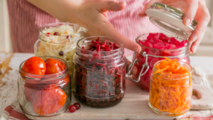 Einmachgläßer in dem fermentierte Tomaten, Karotten, Kraut und Sellerie zu sehen sind
